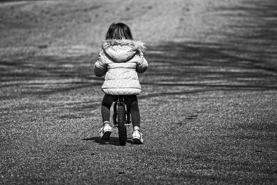 balans meisje op fiets zwart wit